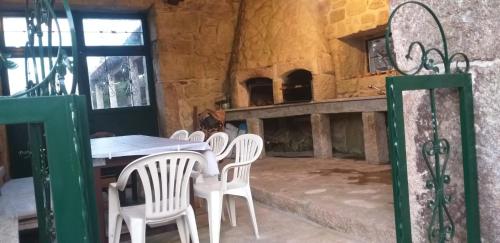 tavolo e sedie in una stanza con camino di Quinta do Ferrador a Viana do Castelo