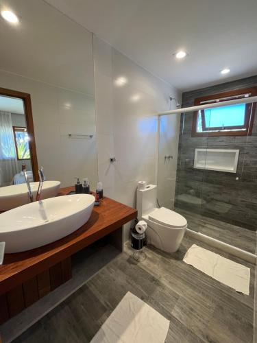 uma casa de banho com um lavatório, um WC e um chuveiro em Charmoso Chalet em Teresópolis