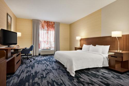 a hotel room with a bed and a flat screen tv at Fairfield Inn & Suites by Marriott Hershey Chocolate Avenue in Hershey