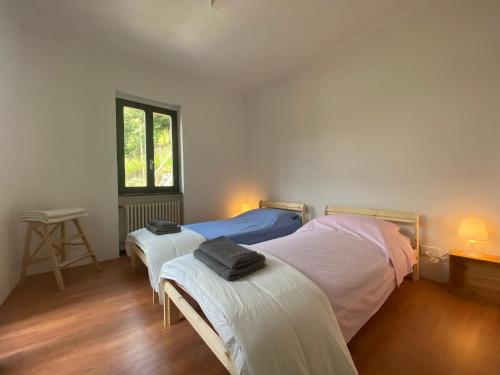a bedroom with two beds and a table and a window at Casa Bellavista - Serena in Lugano