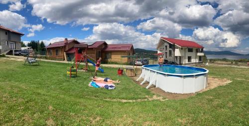 席闊維沙爾克的住宿－Къщи Мaхони，一群儿童在带游泳池的院子玩耍