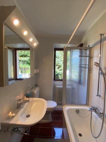 a bathroom with a sink and a tub and a toilet at Casa Bellavista - Serena in Lugano