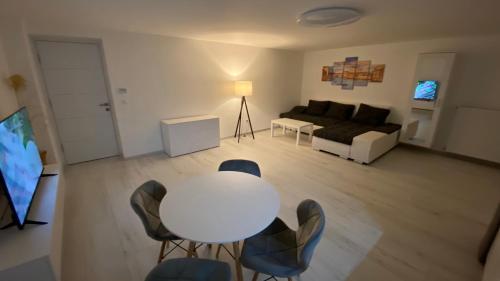 ein Wohnzimmer mit einem weißen Tisch und Stühlen in der Unterkunft Diamond House in Veresegyház