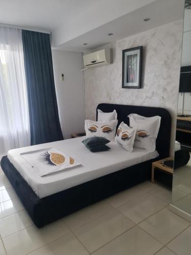 a bedroom with a bed with white sheets and pillows at Casa Day&Amy in Eforie Sud