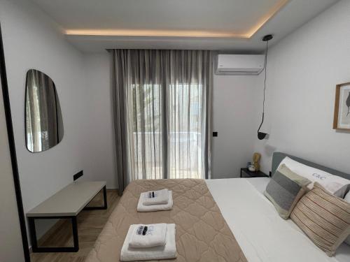 una camera da letto con un grande letto bianco e una finestra di C&C3 Apartments a Alexandroupoli
