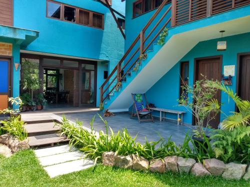 niebieski budynek ze schodami i ławką w obiekcie Pousada Vila Guyrá w mieście Florianópolis