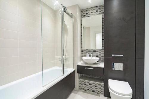y baño con aseo, lavabo y ducha. en Room with private bathroom in a modern two bedroom two bathroom flat en Londres