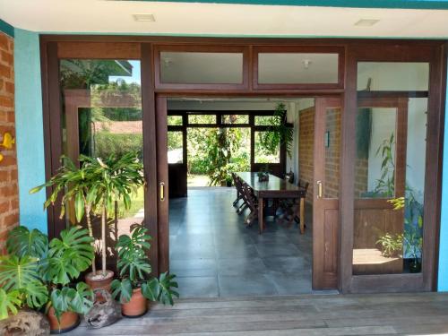 an open glass door of a house with a table at Pousada Vila Guyrá in Florianópolis