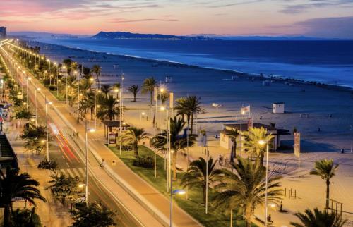 a city street with palm trees and the beach at night at Villa GAN EDEN in La Drova