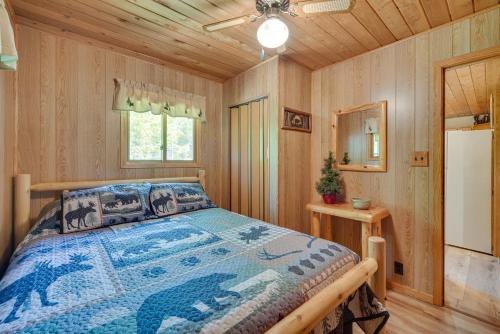 a bedroom with a bed in a log cabin at Waterfront Cameron Retreat with Grill and Fire Pit! in Barron