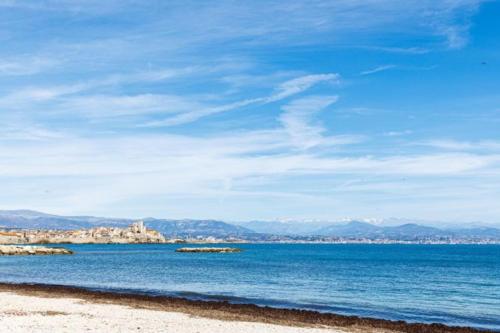 - une vue sur la plage avec une ville en arrière-plan dans l'établissement Tamanaco Beach 1BDR apartment with balcony sea view and pool, à Antibes