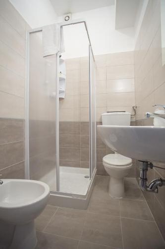 a bathroom with a shower and a toilet and a sink at Hotel Paradiso in Senigallia