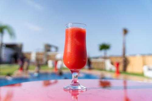 uma bebida num copo sentado numa mesa ao lado de uma piscina em CASA DEL TITO em Oulad Akkou