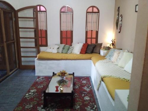 a living room with two beds and a couch at Hostel Mazoca in Peruíbe