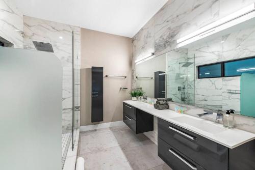 a bathroom with two sinks and a glass shower at Coconut Grove Villa with heated Pool sleeps 12 in Miami