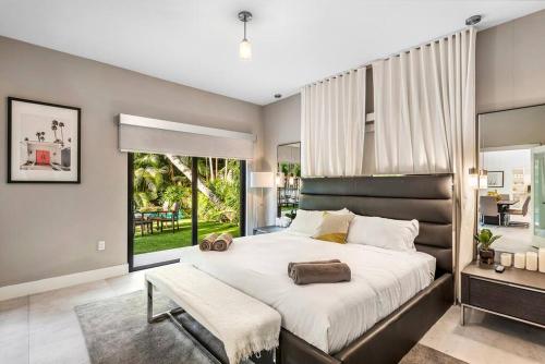 a bedroom with a large bed and a large window at Coconut Grove Villa with heated Pool sleeps 12 in Miami