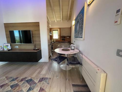 a dining room with a table and a kitchen at Antica Fonte Holiday Homes in San Pantaleo
