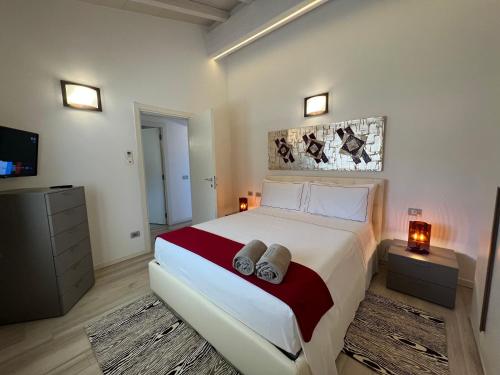 a bedroom with a large bed and a tv at Antica Fonte Holiday Homes in San Pantaleo