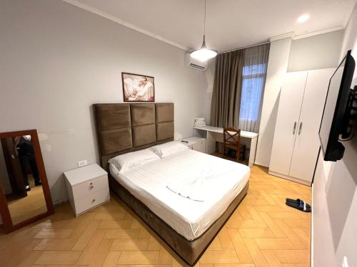 Un dormitorio con una cama y una mesa. en HOTEL NOBEL CENTER en Tirana