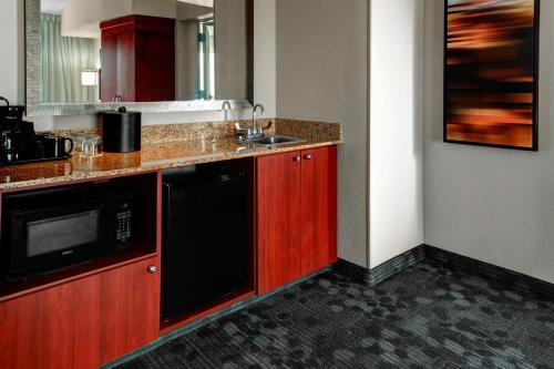 a kitchen with a sink and a microwave at Courtyard by Marriott Anniston Oxford in Oxford