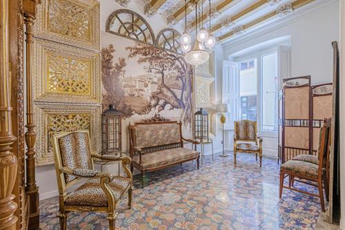 卡内·德·玛尔El Petit Palauet的一间设有椅子的房间和墙上的绘画