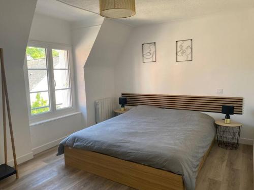a bedroom with a bed and two lamps on two tables at *La Factory / Saint Aignan in Saint-Aignan