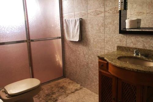 La salle de bains est pourvue d'une douche, de toilettes et d'un lavabo. dans l'établissement Casa de campo com piscina, mesa de bilhar e 3 quartos, à Itanhandu