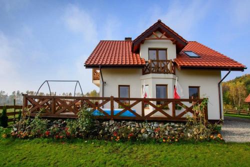 a small white house with a red roof at Chatki Szymonówko in Małdyty