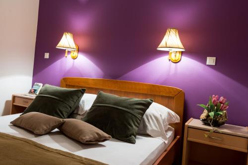 a bedroom with purple walls and a bed with pillows at Apartments Dubrovnik Lapad in Dubrovnik