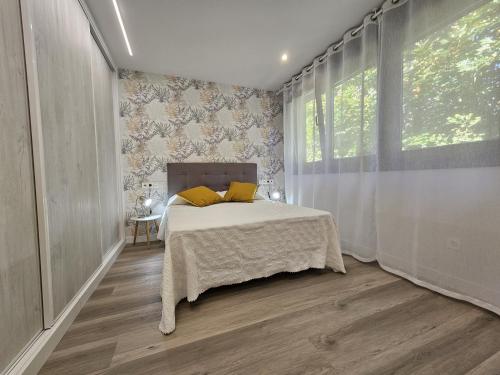una camera da letto con un letto con cuscini gialli e una finestra di 1B105 Bonito apartamento en zona exclusiva a Gijón