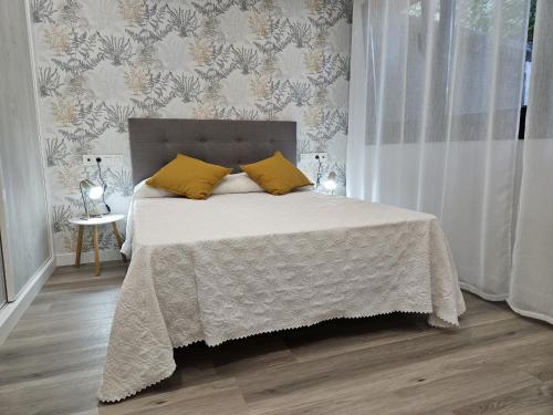 a bedroom with a large bed with yellow pillows at 1A105 Precioso apartamento en zona exclusiva in Gijón