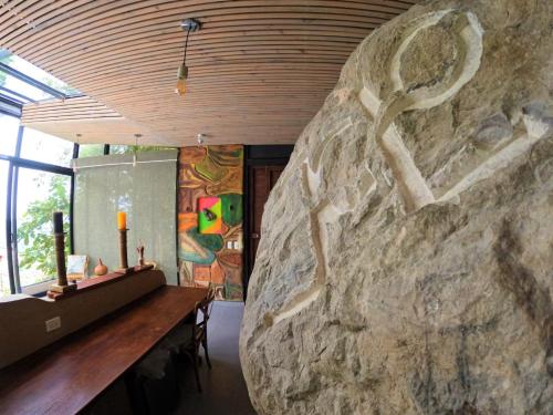 拉梅薩的住宿－Eco Lodge Macabaña Rupestre，一间设有大岩墙和一张桌子的房间