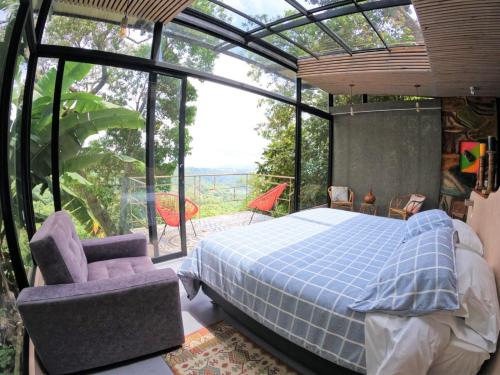 a bedroom with a bed and a large window at Eco Lodge Macabaña Rupestre in La Mesa