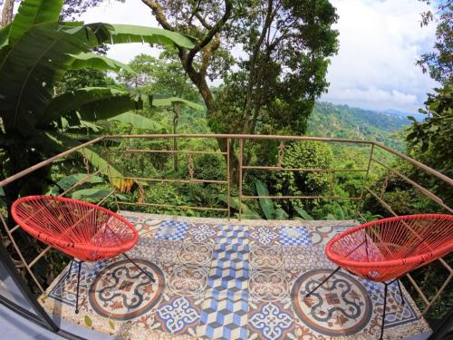 拉梅薩的住宿－Eco Lodge Macabaña Rupestre，阳台配有2把红色椅子和桌子