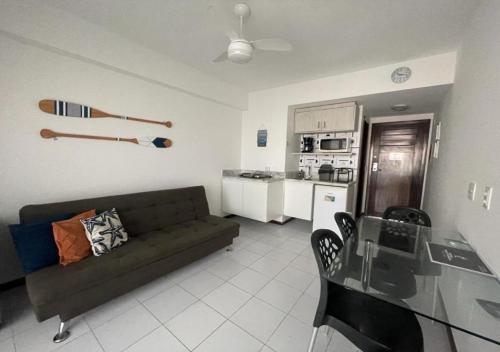 sala de estar con sofá, mesa y cocina en Araça Praia Flat - Ap 507 - Vista Mar, en Natal