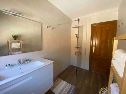 a bathroom with a sink and a shower with a mirror at La Casa de Enzo in Argoños