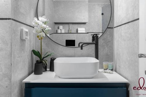 a bathroom with a sink and a mirror at סוויטת View חדר שינה וסלון במתחם סי סייד in Eilat