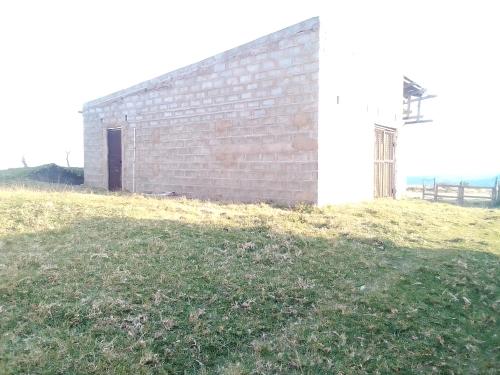 a brick building on top of a grass field at Tshezi Family in Ngqeleni