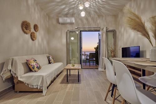 a living room with a table and chairs and a dining room at Pelagaki Sunrise in Orthoniaí