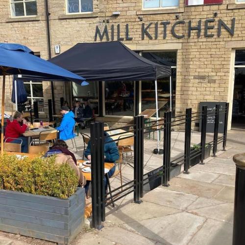 a group of people sitting at tables outside a restaurant at Farsley Studio in Farsley