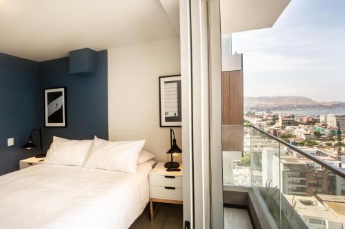 a bedroom with a bed and a large window at Pionero by Wynwood House in Lima