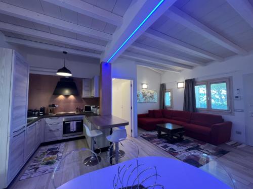 a living room with a red couch and a kitchen at Antica Fonte Holiday Homes in San Pantaleo