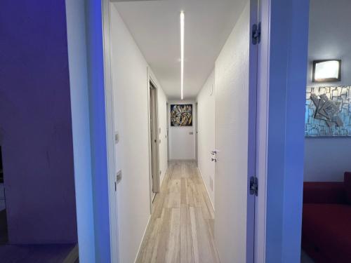 a hallway with white walls and a blue door at Antica Fonte Holiday Homes in San Pantaleo