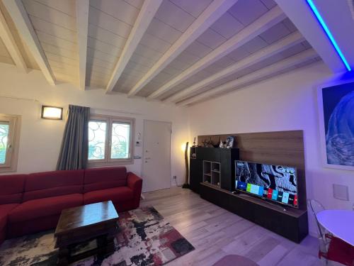 a living room with a red couch and a flat screen tv at Antica Fonte Holiday Homes in San Pantaleo