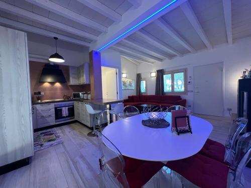 a living room with a white table and a kitchen at Antica Fonte Holiday Homes in San Pantaleo
