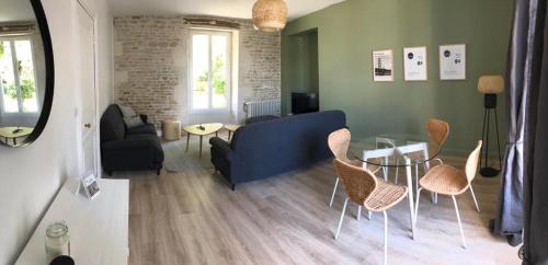 un salon avec un canapé bleu et des chaises dans l'établissement Maison de vacances familiale au cœur du marais poitevin, à Maillezais