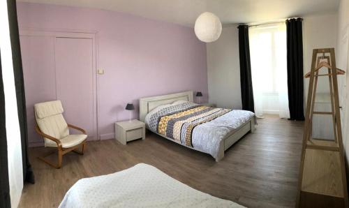 una camera con letto, sedia e scala di Maison de vacances familiale au cœur du marais poitevin a Maillezais