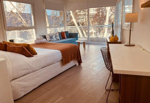 Sucre Suites في بوينس آيرس: غرفة نوم بسرير واريكة ونوافذ