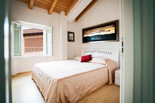 een slaapkamer met een wit bed en een rood kussen bij B&B RED WINE COUNTRY HOUSE in Castel San Pietro Terme