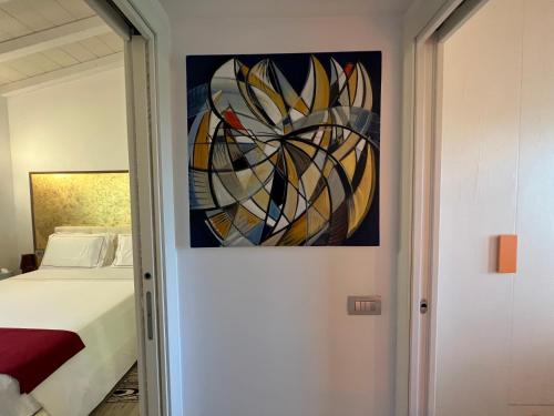 a bedroom with a painting on the wall next to a bed at Antica Fonte Holiday Homes in San Pantaleo
